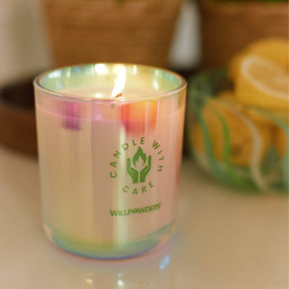 Candle with 'Candle with Care' and 'Willpowders' branding, lit on a surface.