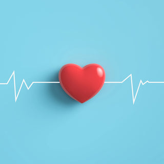 A red heart shape is centered on a light blue background. A white electrocardiogram (EKG) line runs horizontally across the image, passing through the heart. The EKG line has peaks and valleys representing a heartbeat.
