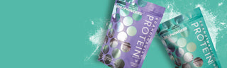 Two colourful, of WillPowders Protein on a teal background. The left pouch is purple, and the right is green, with some powder spilled around them.