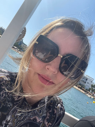 A WillPowders customer wearing sunglasses in a seaside location