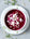 a whote bowl containing purple beetroot soup on a grey background 
