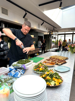 A chef seasoning food in a large kitchen
