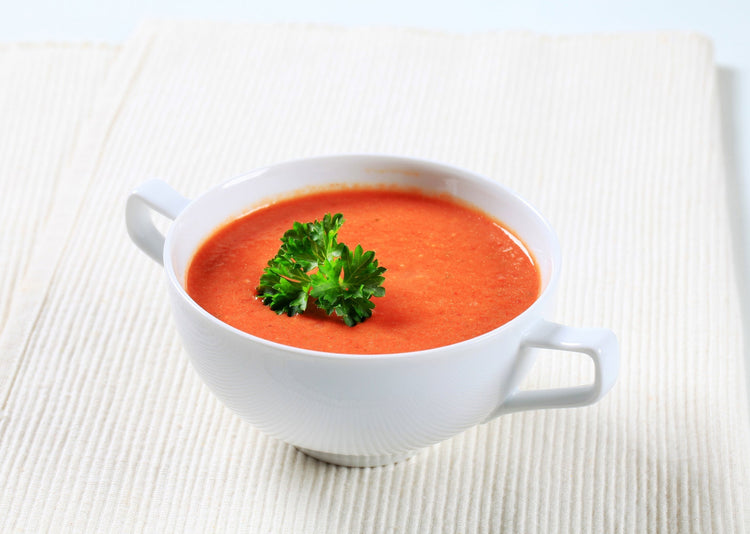 red pepper soup in a white bowl 