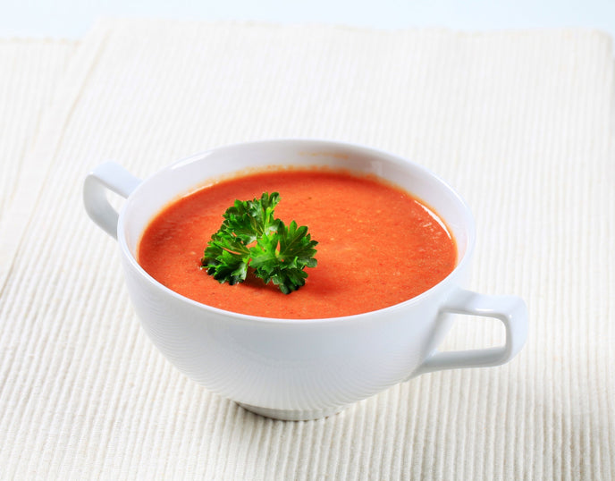 red pepper soup in a white bowl 