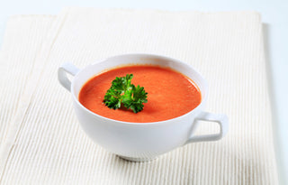 red pepper soup in a white bowl 