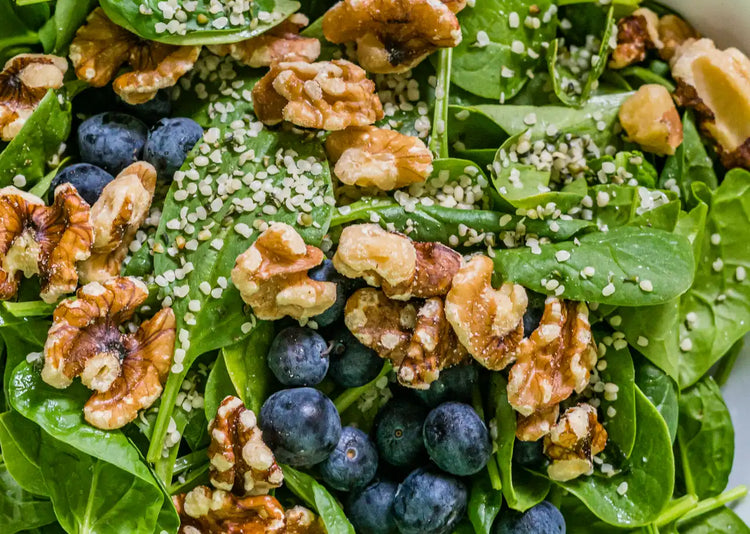 A Spinach, Blueberry and Walnut Salad in a white bowl