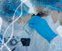 A scientist in a lab coat, gloves, and protective eyewear is looking into a microscope. There is a blue double helix DNA model and chemical formulas overlaid on the image