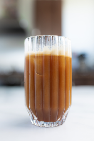 Tall glass with iced coffee, with a blurred background