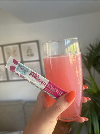 Hand holding a glass with WillPowders Electrotide hydration