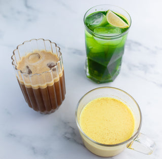3 glasses of detox drinks; one contains iced coffee, one contains a turmeric drink, one contains a green drink with a lemon slice