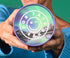 Woman holding a Protein Powder tub showing the lid with the text For Fats Sake, white text on a mountain range background