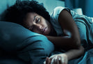 Person sleeping on a blue bed