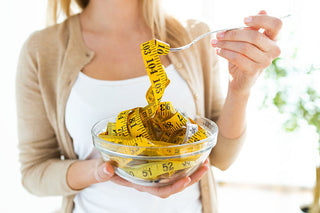 woman holding bowl with measuring tapes at home